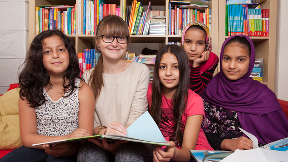 Gruppenbild von fünf Mädchen des LernLEOs, die in Heft blättern