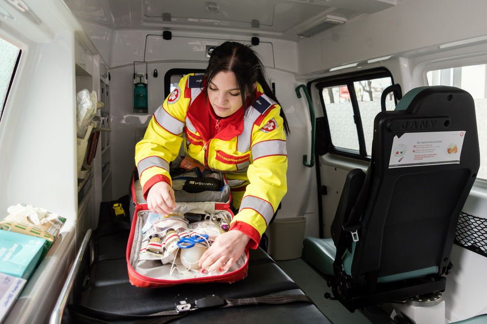 Sanitäterin kontrolliert Einsatzrucksack im Einsatzfahrzeug